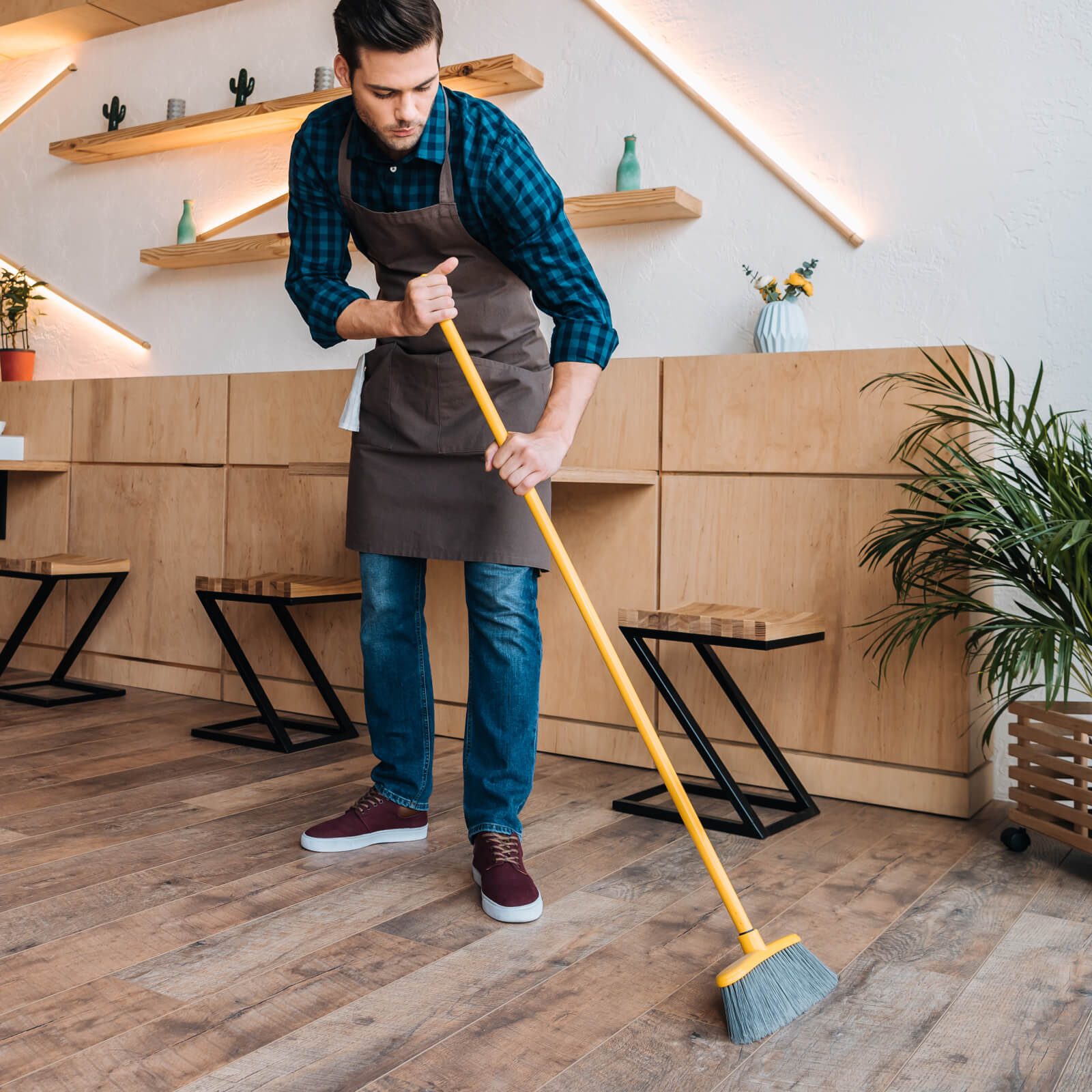 Man sweeping hardwood floor | Custom Floors